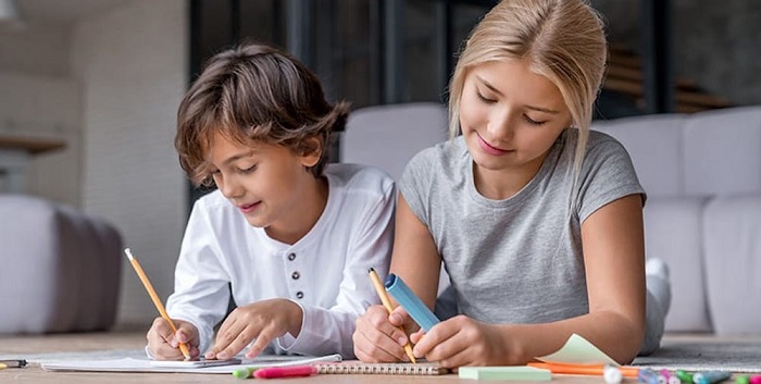 Focussed & Young Children Writing On The Note With Pencil.