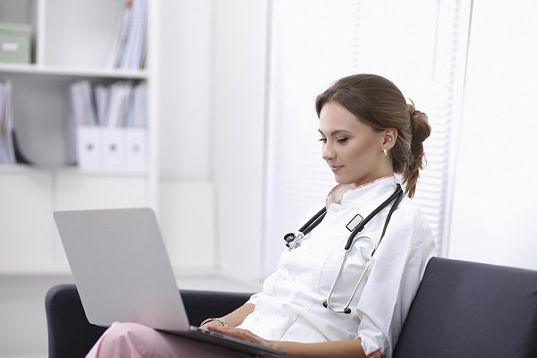 A Young Female Doctor Working In A Laptop.